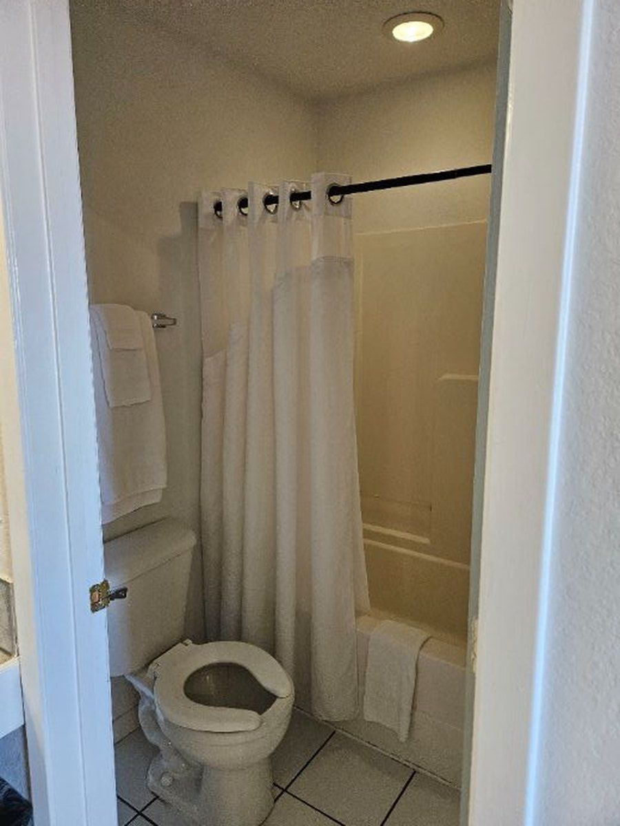 Small bathroom with toilet, bathtub, and shower curtain