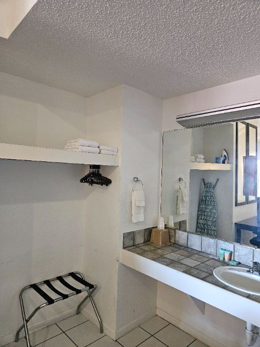 Bathroom with a white shelf holding towels