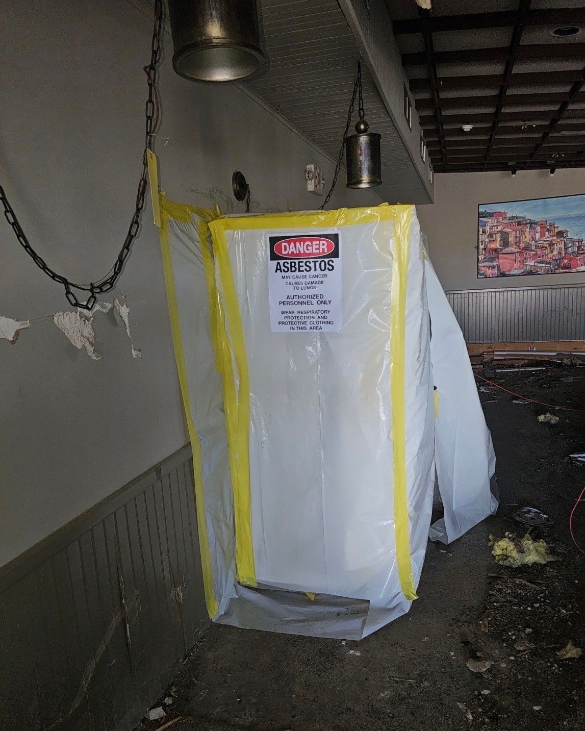 Yellow-taped covered object in a dim indoor area, with a warning sign on the front.