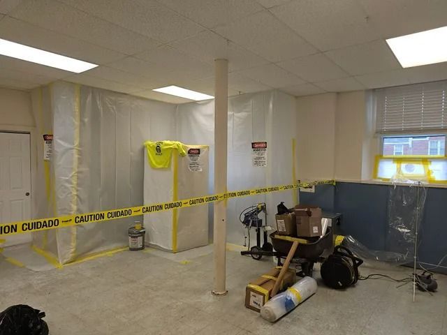 Caution-taped room under renovation with drywall, tools, and construction materials inside