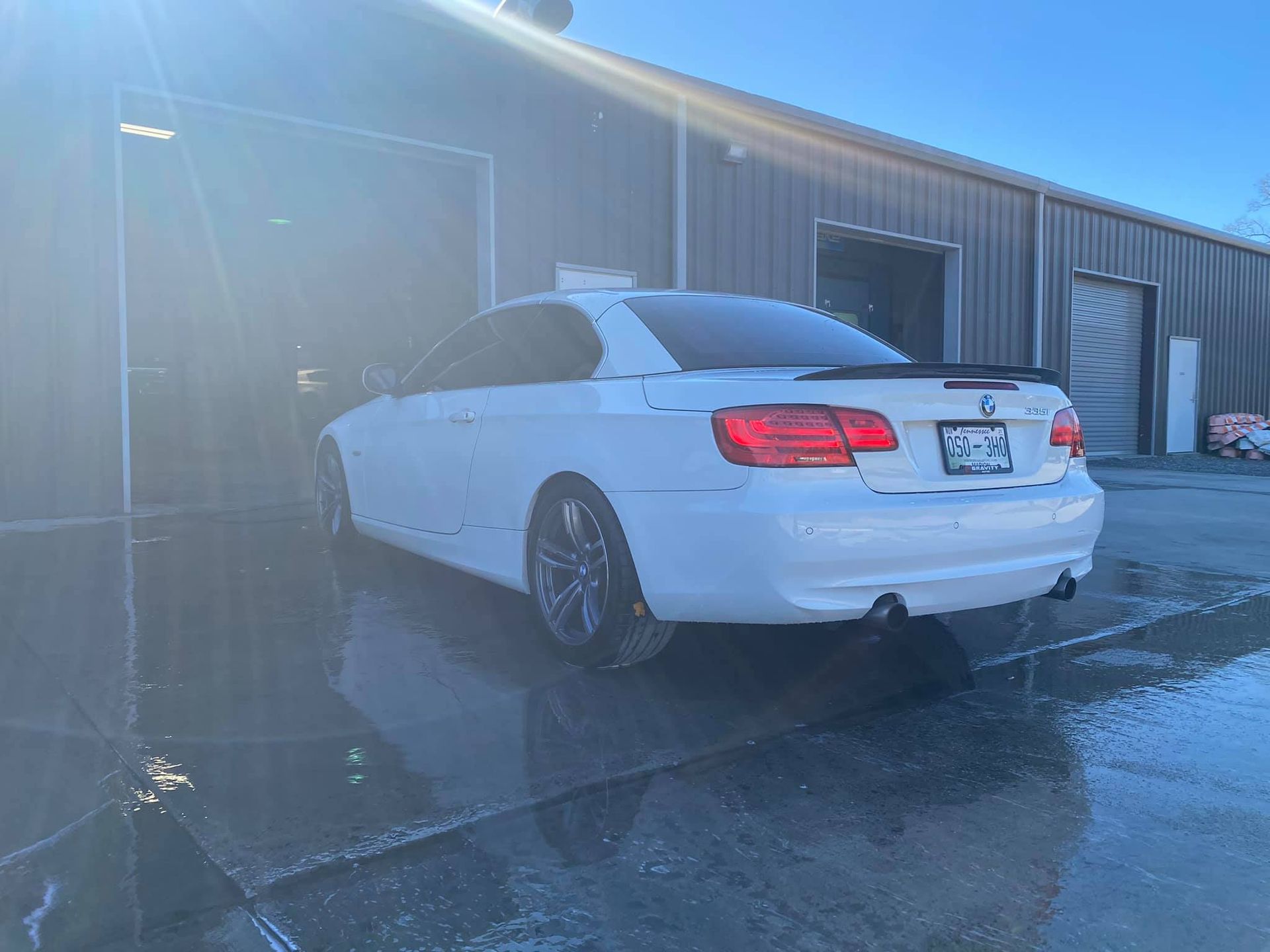 A white car is parked in front of a building.