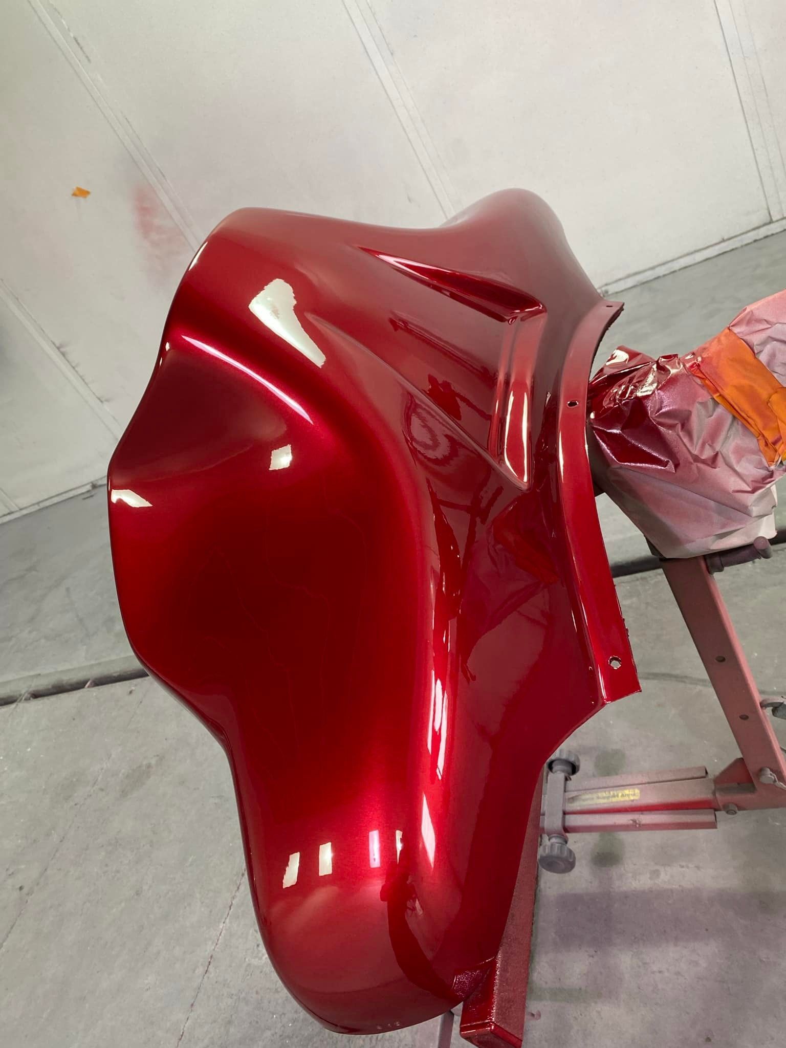 A red motorcycle is sitting on a paint stand