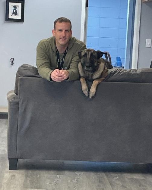 A man and a dog are sitting on a couch.