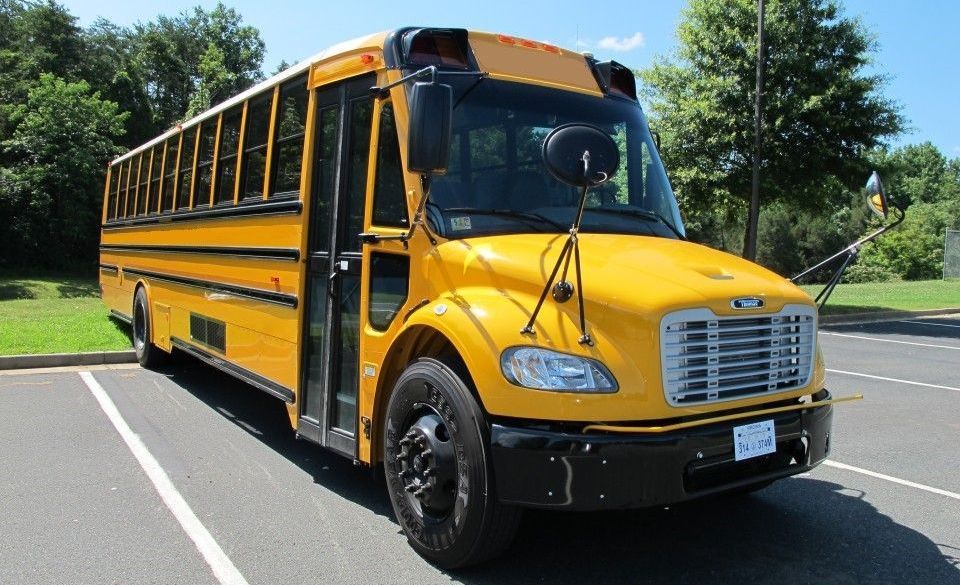 A yellow school bus is parked in a parking lot.