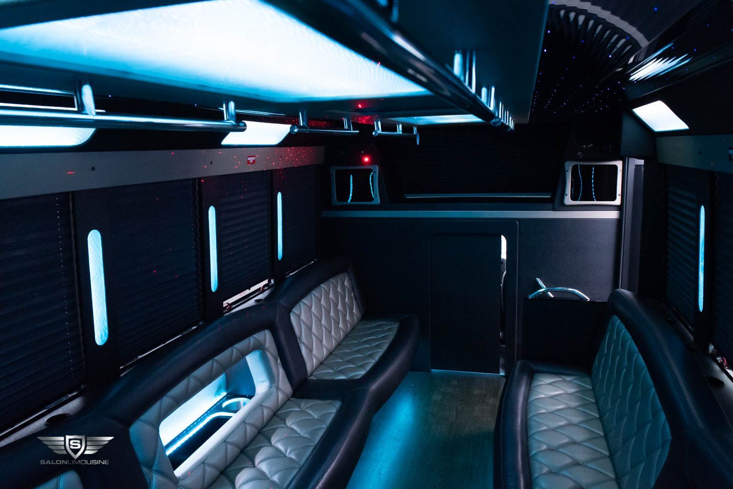 The inside of a limousine with blue lights on the ceiling.