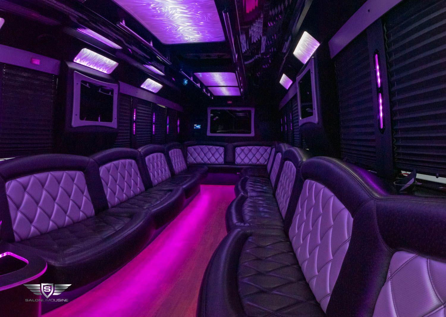 The inside of a limousine with purple lights on the ceiling.