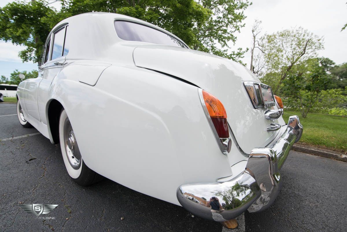 A white car is parked on the side of the road.