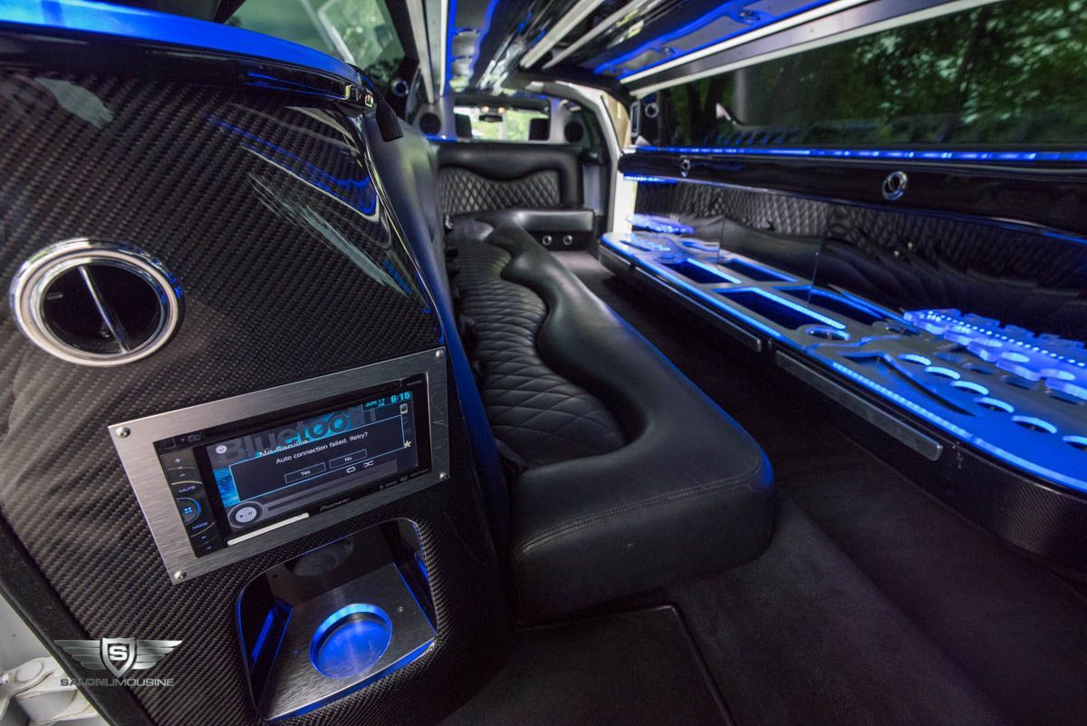 The interior of a limousine with blue lights on the seats.