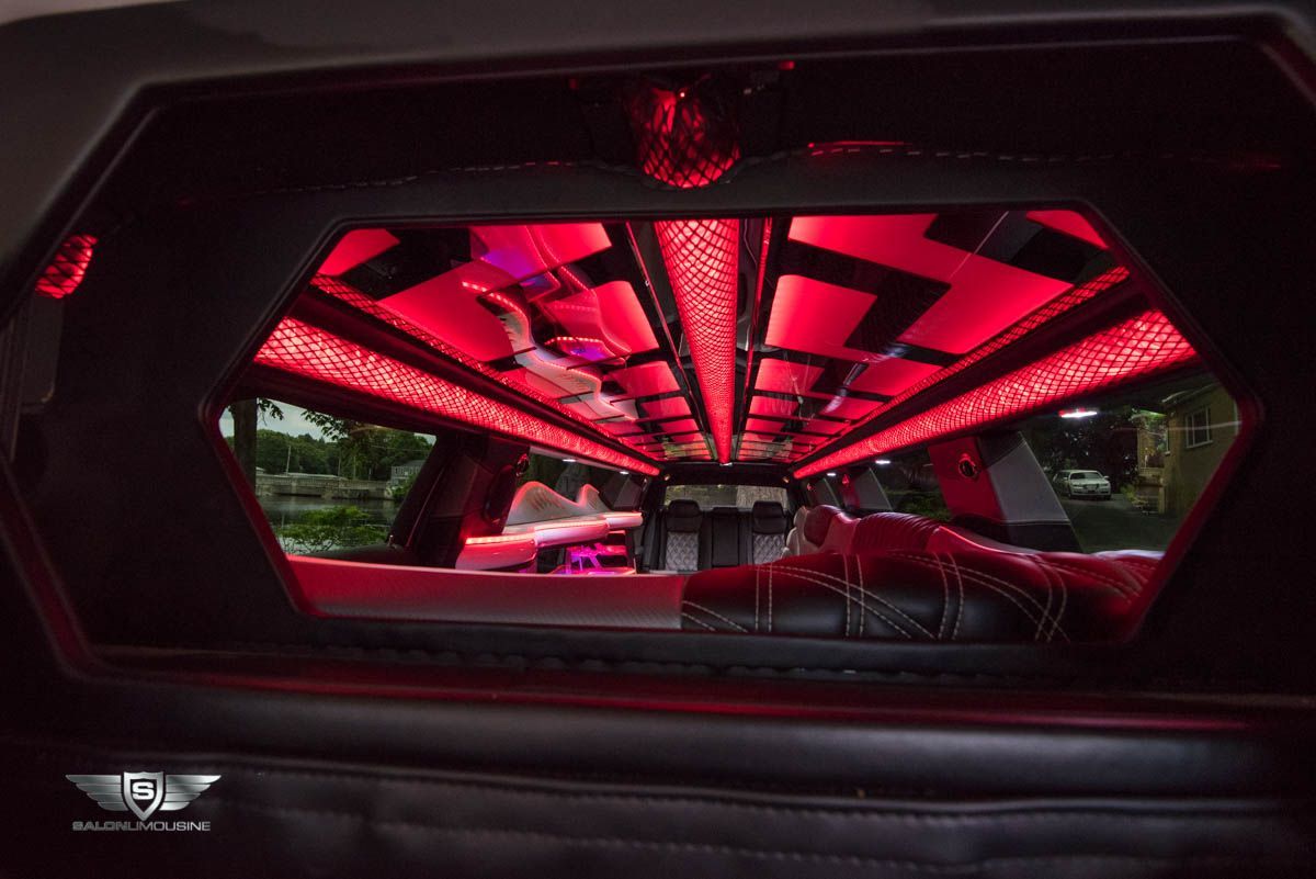 The inside of a limousine with red lights on the ceiling.