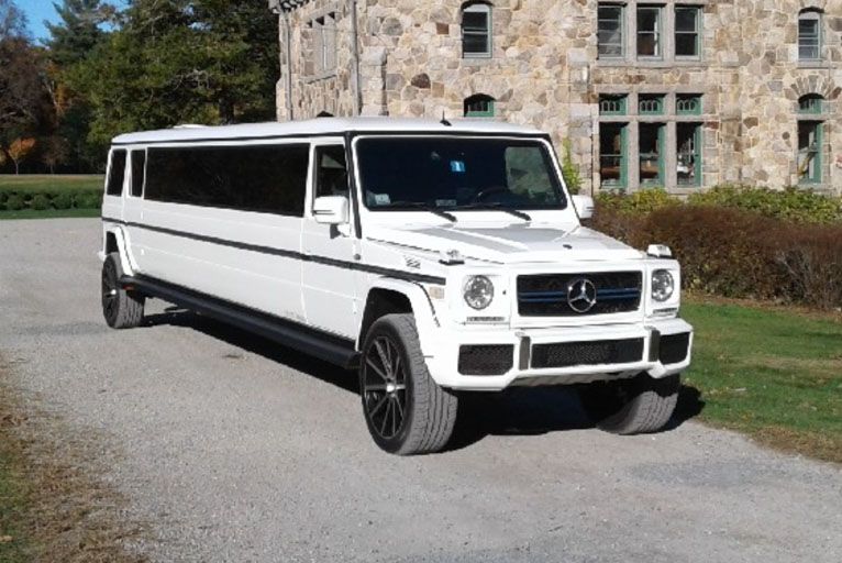 A white limousine is parked in a parking lot.