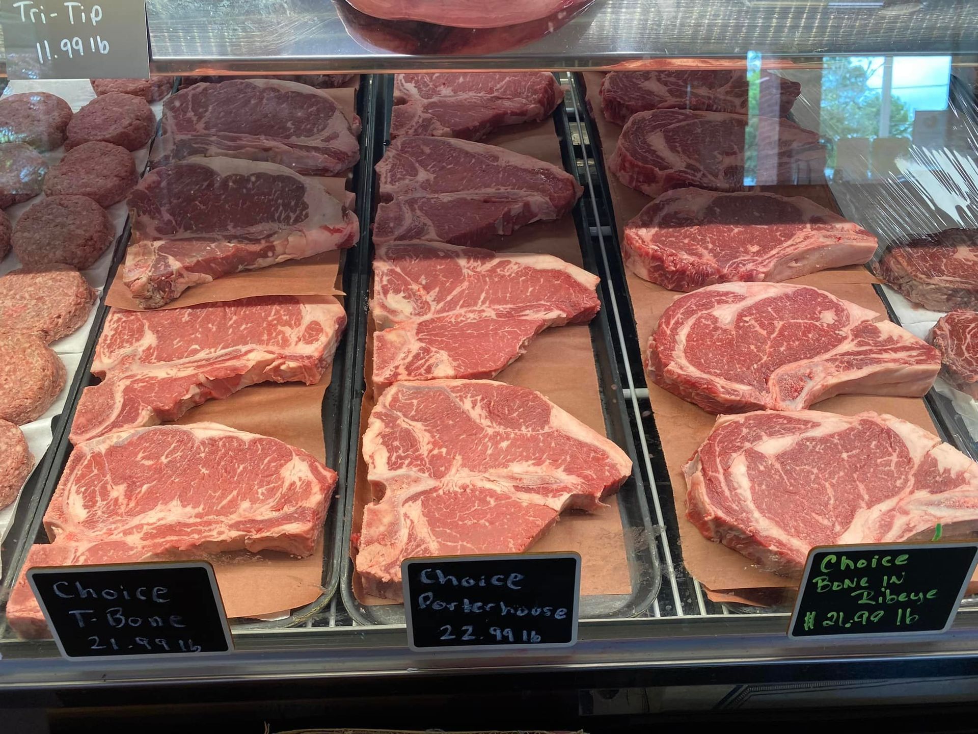 Meat display case with various cuts of raw beef.