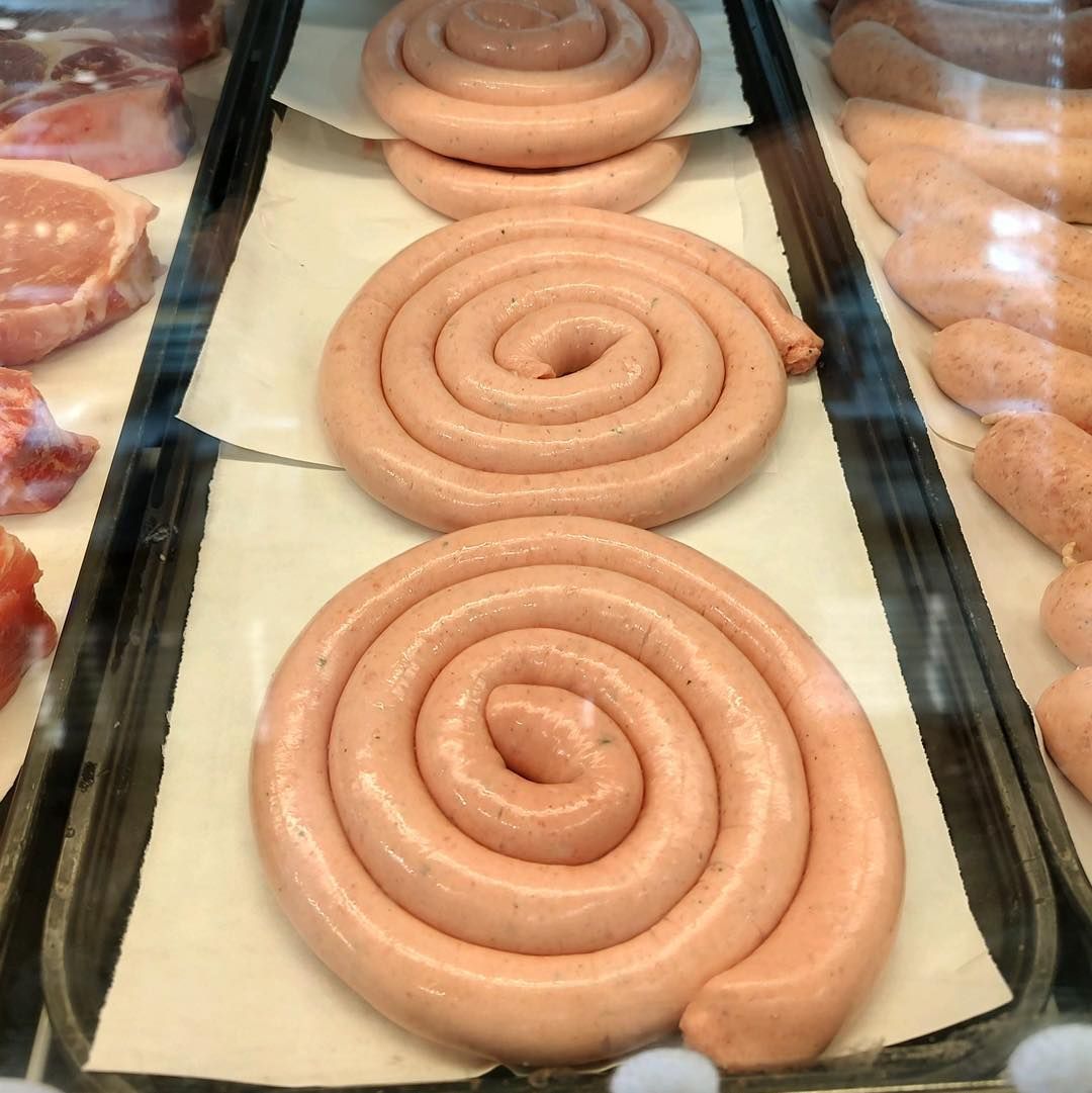 Sausage coils in a butcher shop display case.
