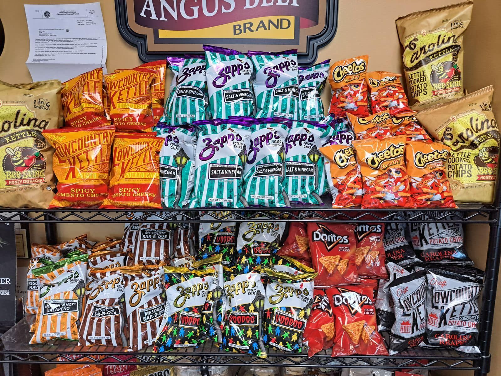 Shelves filled with various colorful bags of chips for sale in a store.
