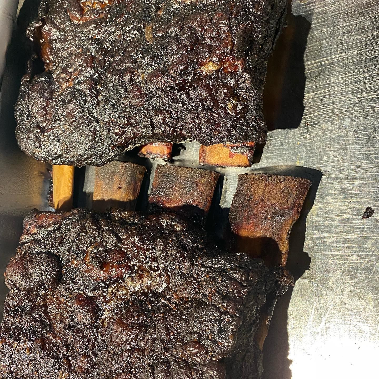 Smoked beef short ribs with dark bark and exposed bones