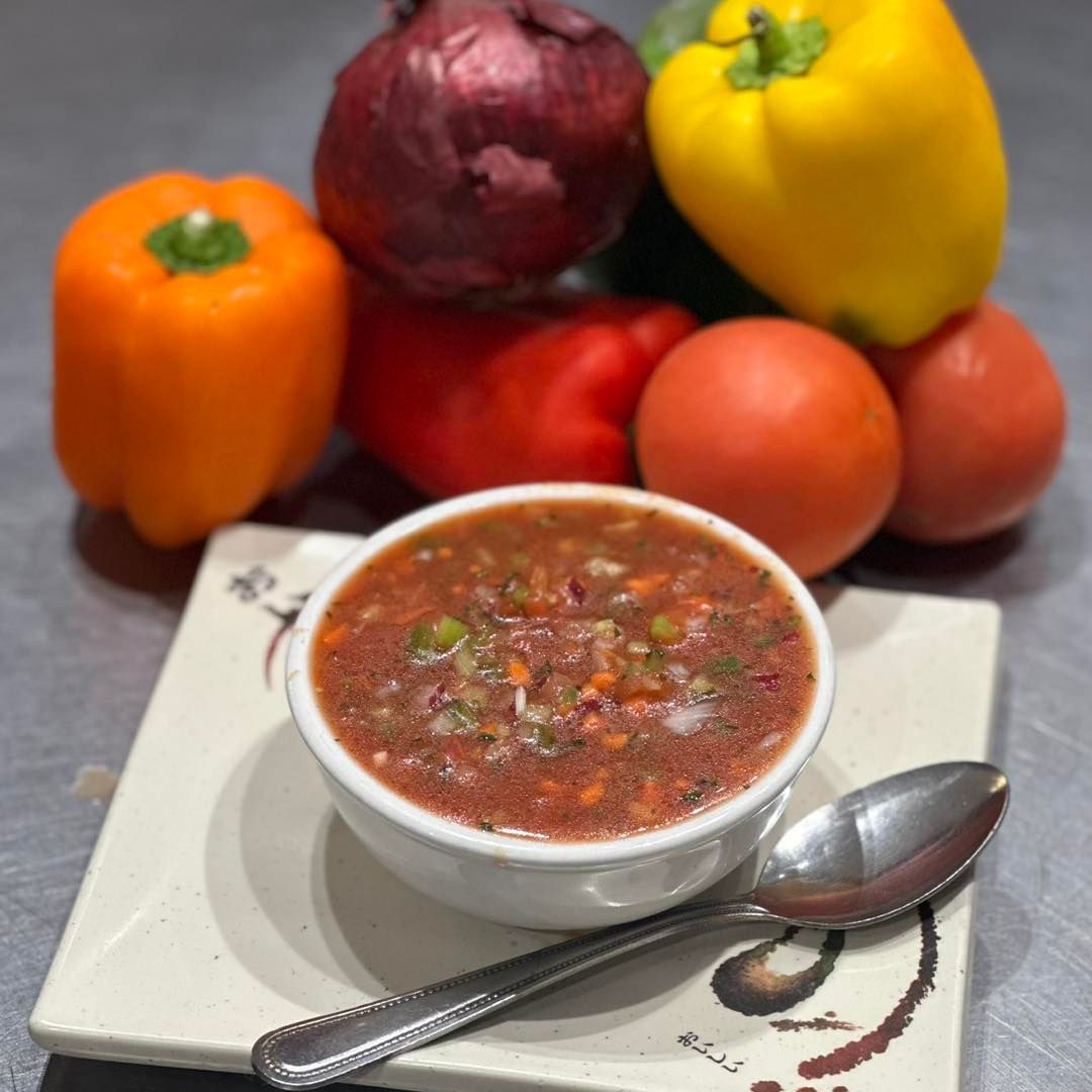 Bowl of gazpacho with tomatoes, peppers, and onion