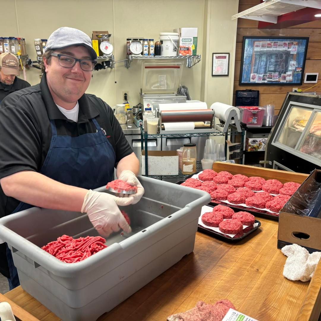 Man in apron and gloves forming burger patties