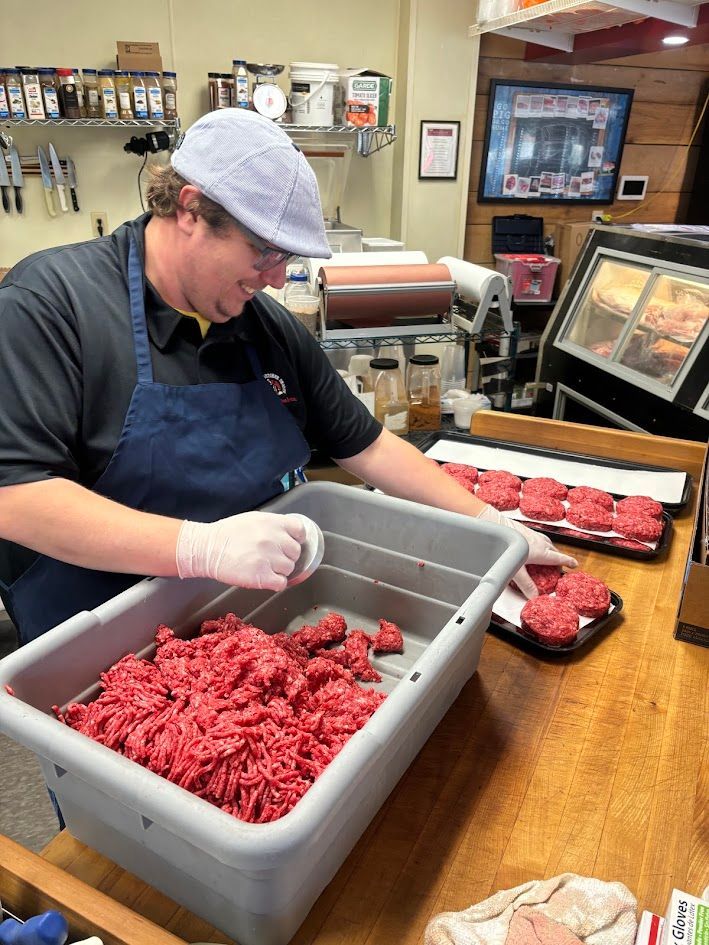 Butcher in a deli shaping burger patties