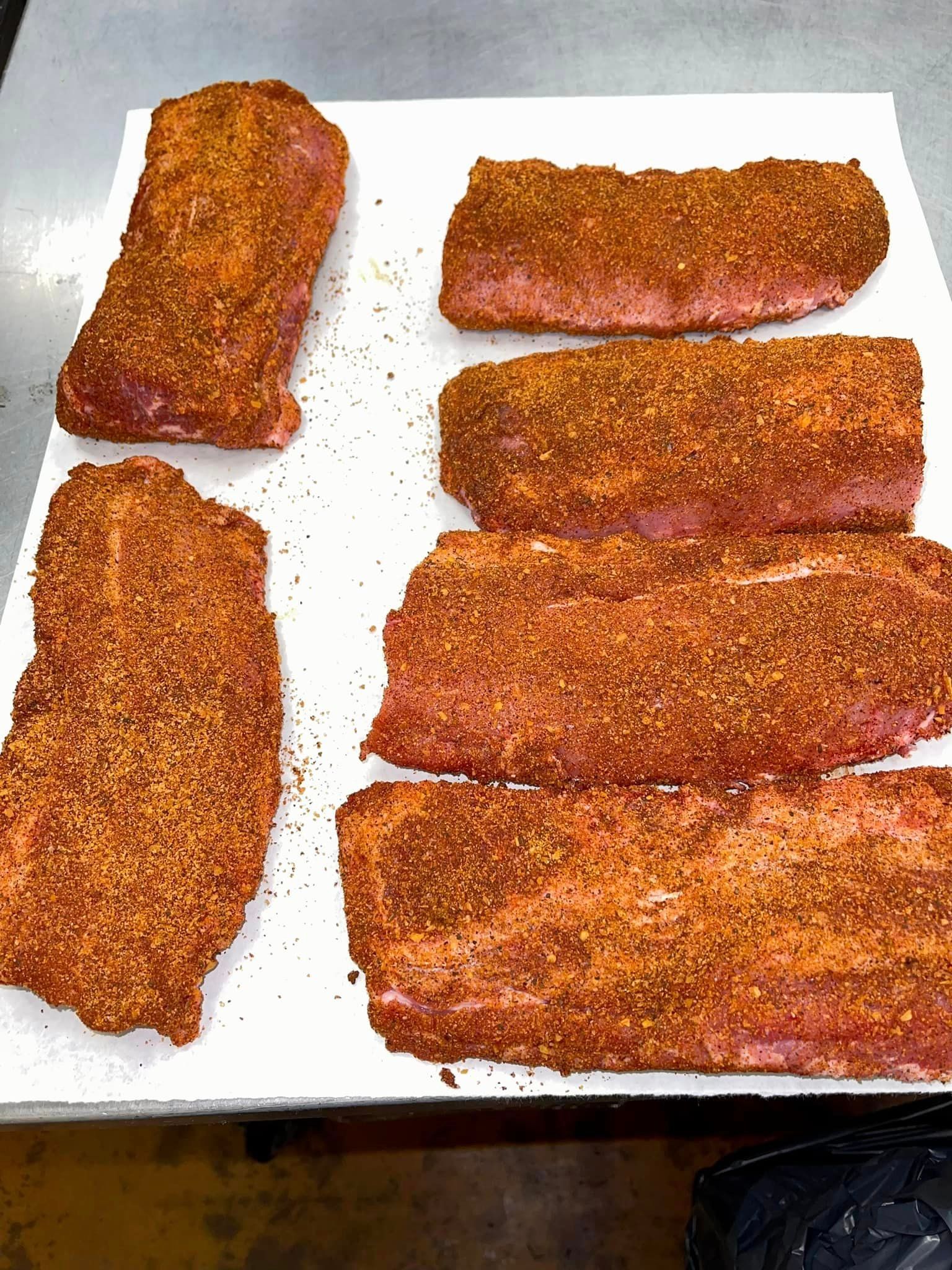Pork ribs coated in seasoning, laid on white paper