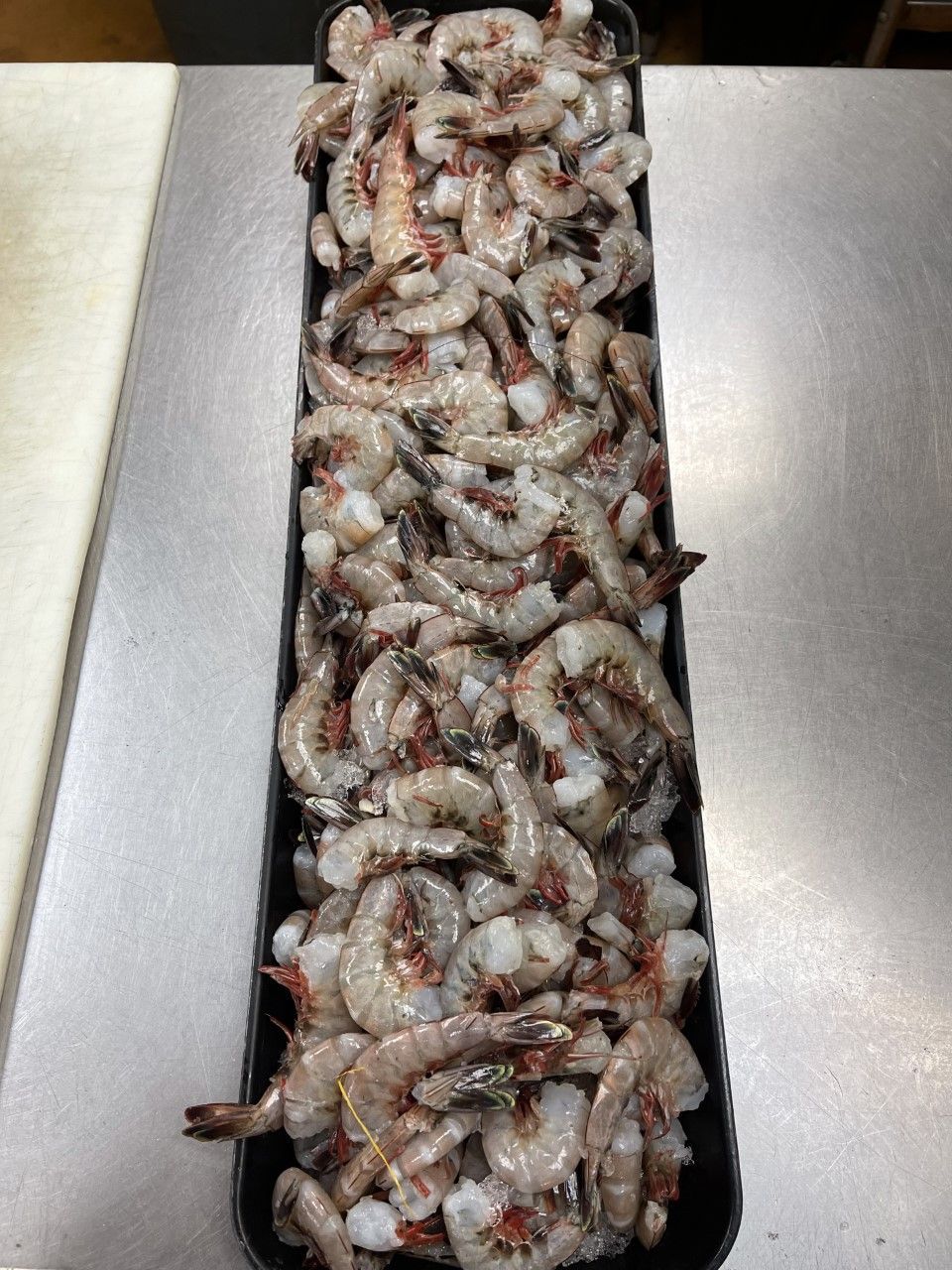 Tray filled with raw, gray shrimp