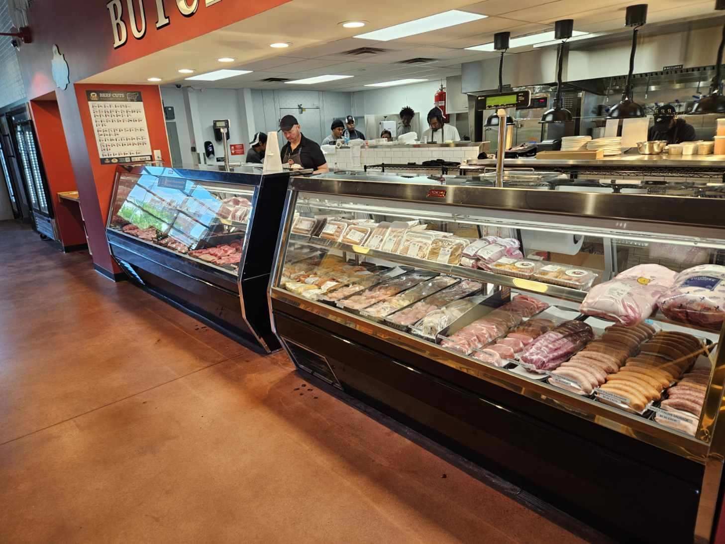 Butcher shop interior with meat displays and employees