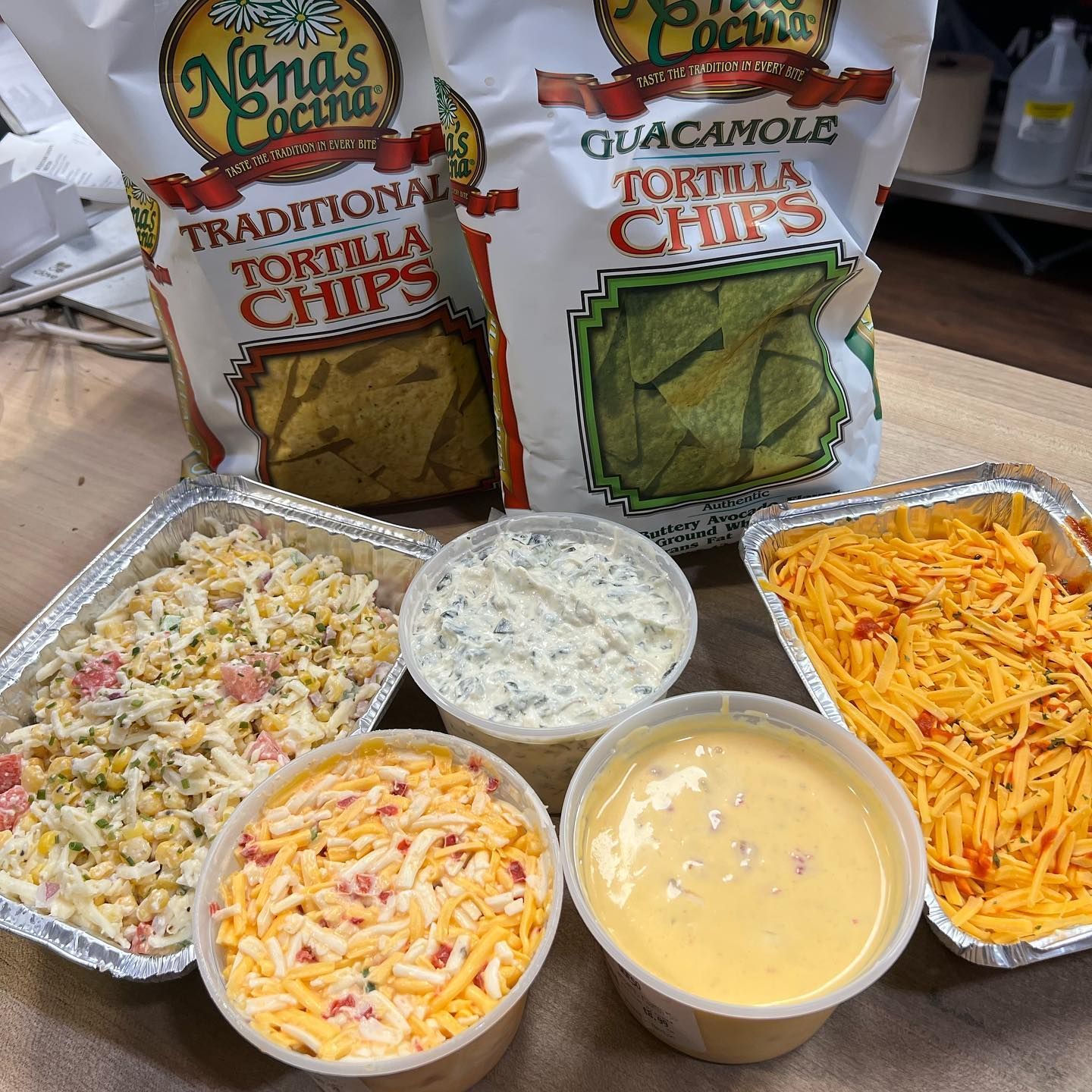 Tortilla chips, dips, and cheese dishes in a store setting.