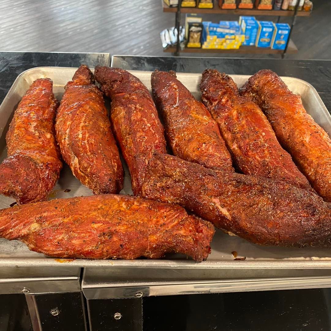 Tray of seasoned, cooked pork tenderloins.