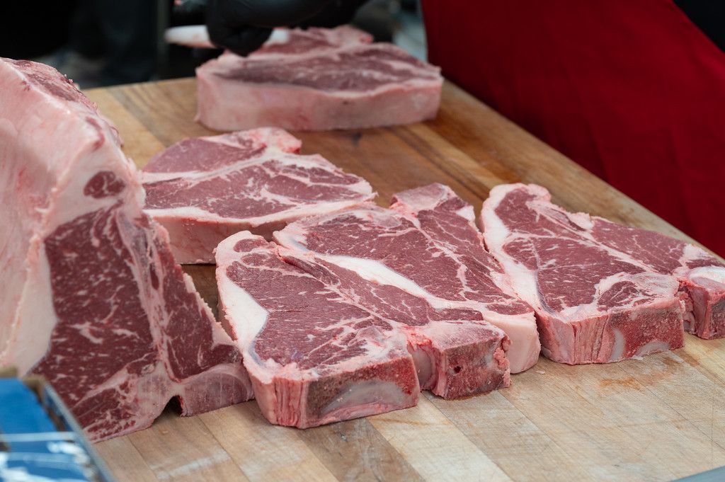Raw lamb chops on a wooden cutting board, ready for cooking.