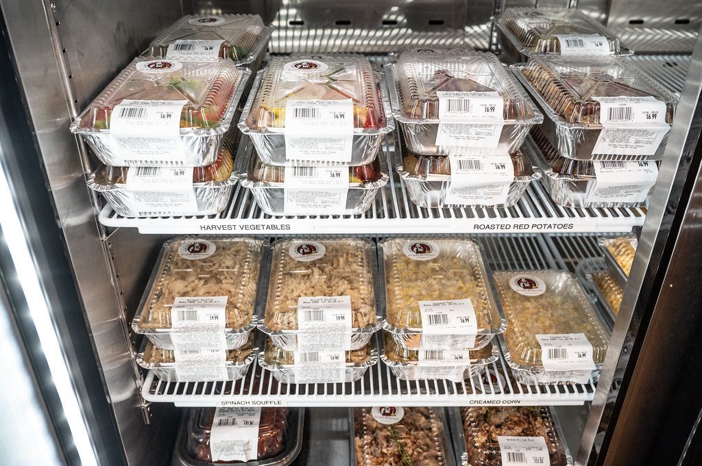 Refrigerated display case filled with pre-packaged food containers, likely for sale in a store.