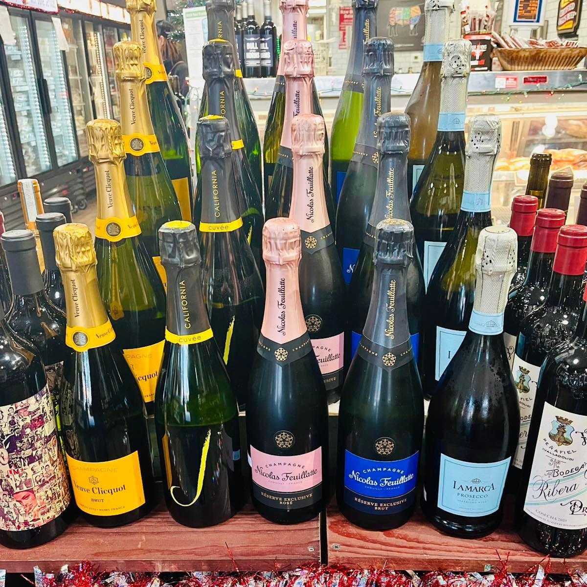 Bottles of sparkling wine displayed for sale, including some with pink labels.