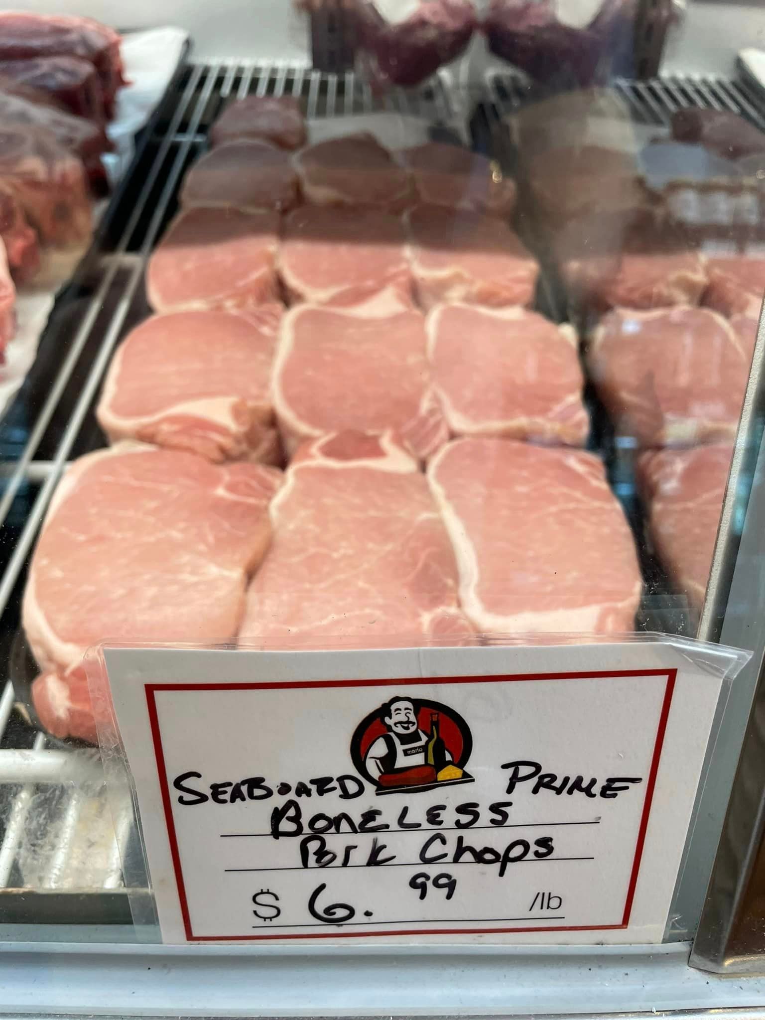 Boneless pork chops at a butcher shop display with a price tag that says $6.99