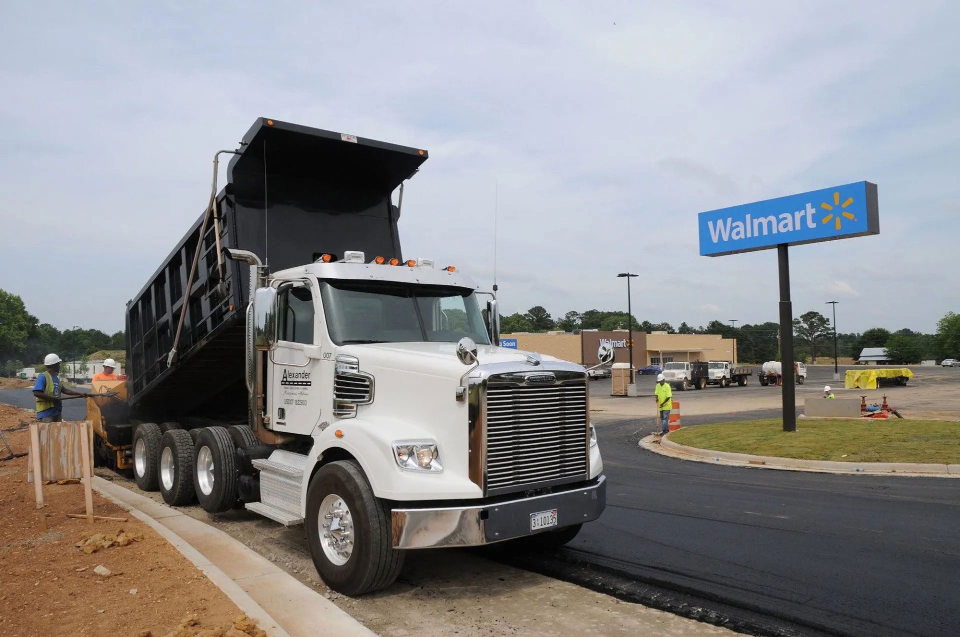 Dump truck at a Walmart construction site with workers nearby