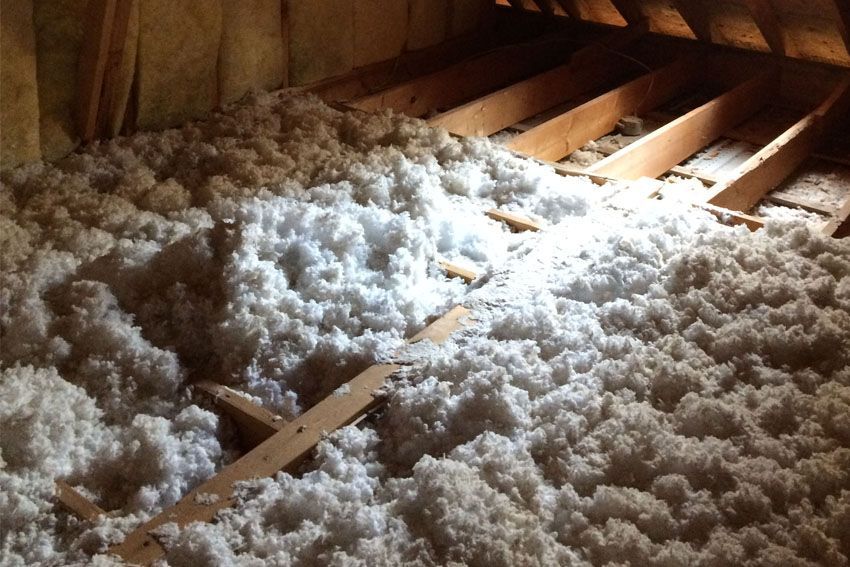 There is a lot of insulation in the attic of a house.