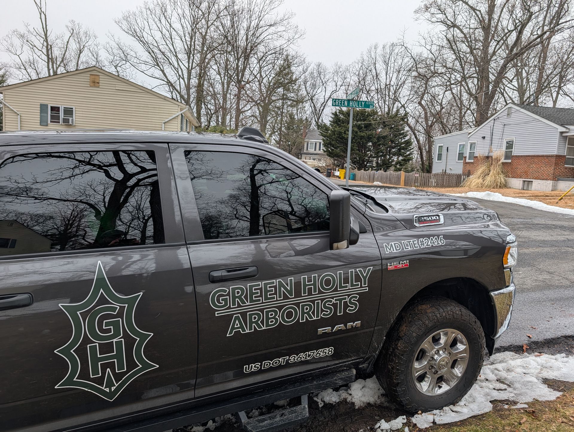 Black Greenfield Arrows truck parked in a snowy neighborhood, with a logo on the door and hood.