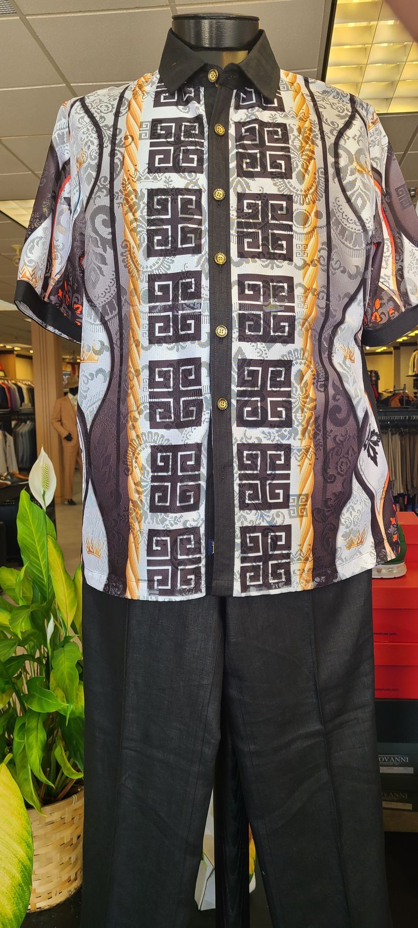Patterned long-sleeve shirt on a black mannequin, paired with dark pants on a display stand.