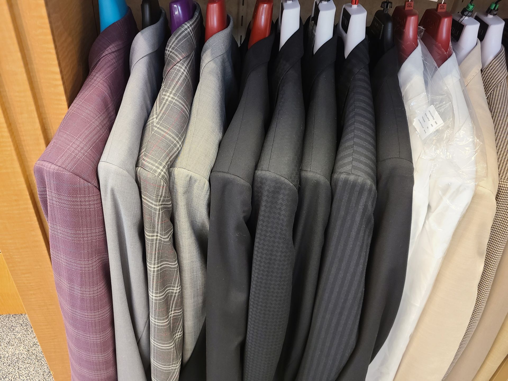 Hanging dress shirts in assorted colors and patterns on a clothing rack