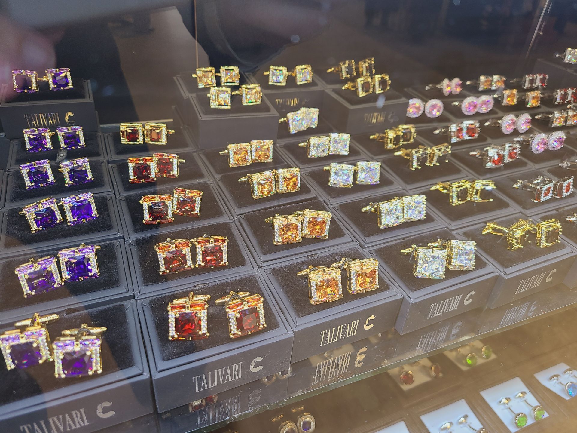 Rows of colorful packaged snacks are displayed in a glass case on labeled shelves.