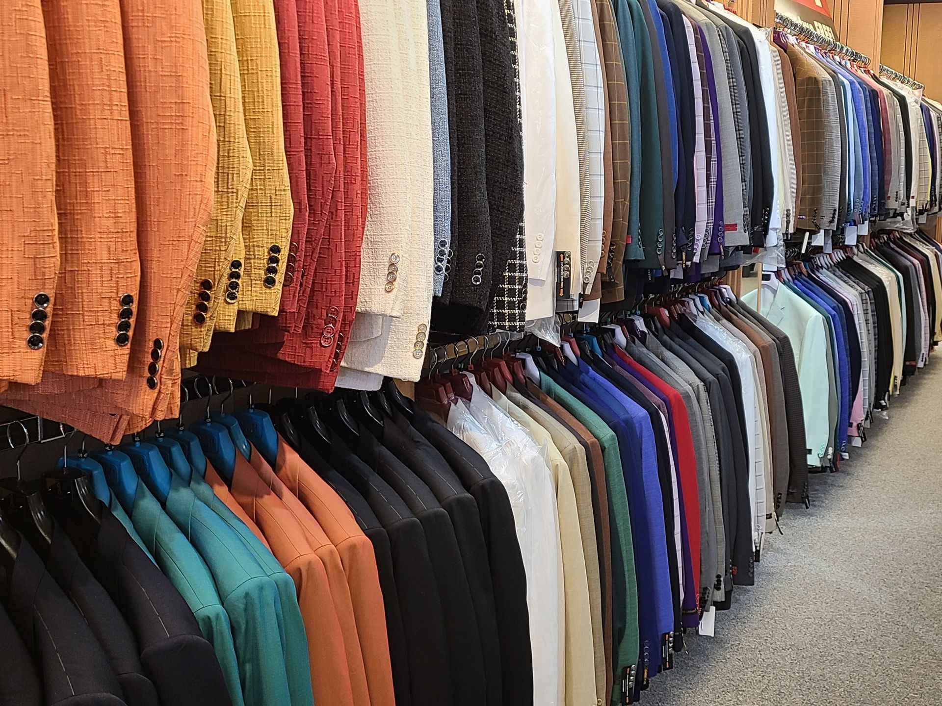 Rows of colorful shirts hanging on racks in a clothing store