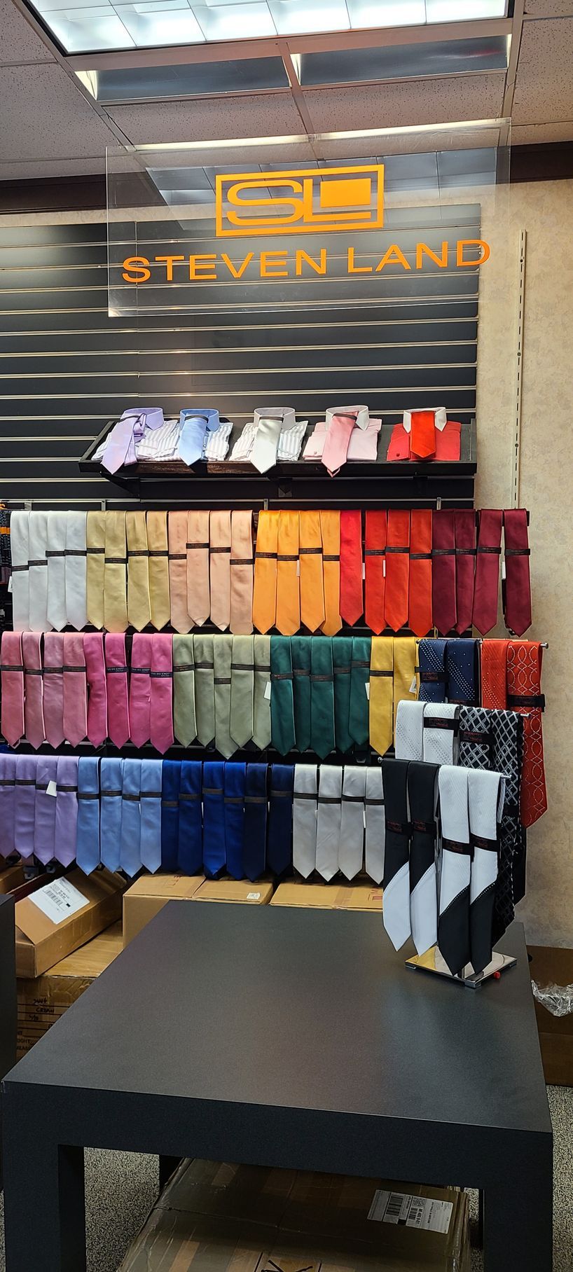 Steven Lane's sock display wall with rows of colorful socks and a black display table in front