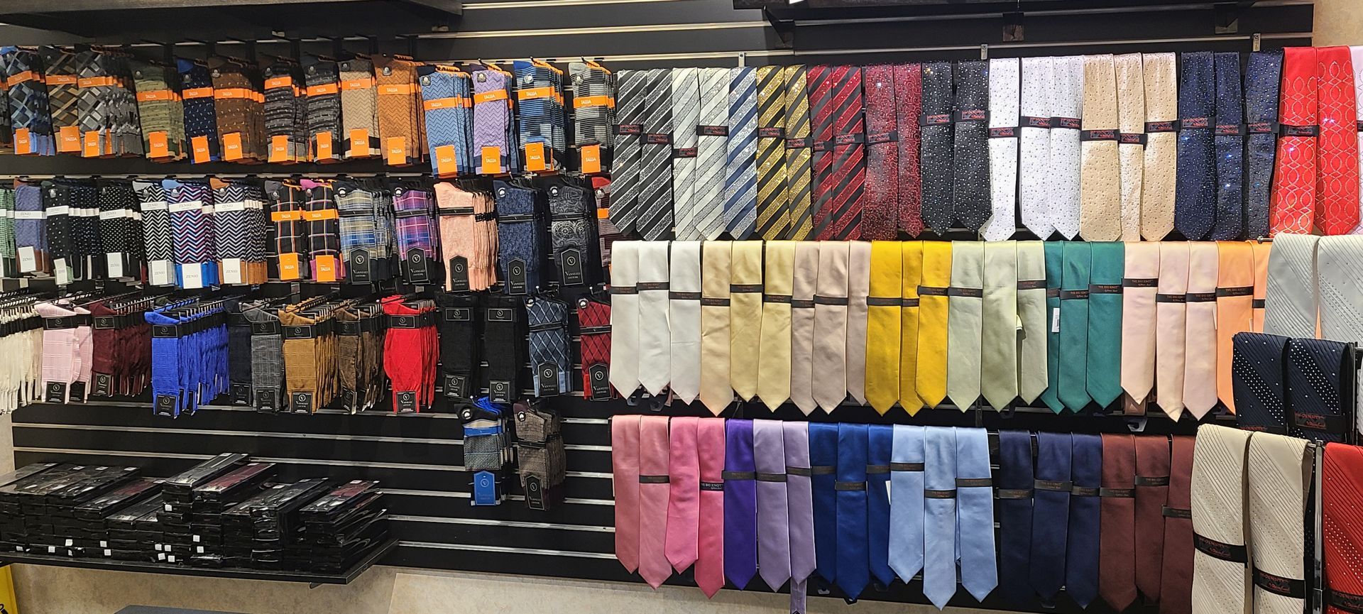 Rows of colorful gloves and socks neatly displayed on shelves in a store.