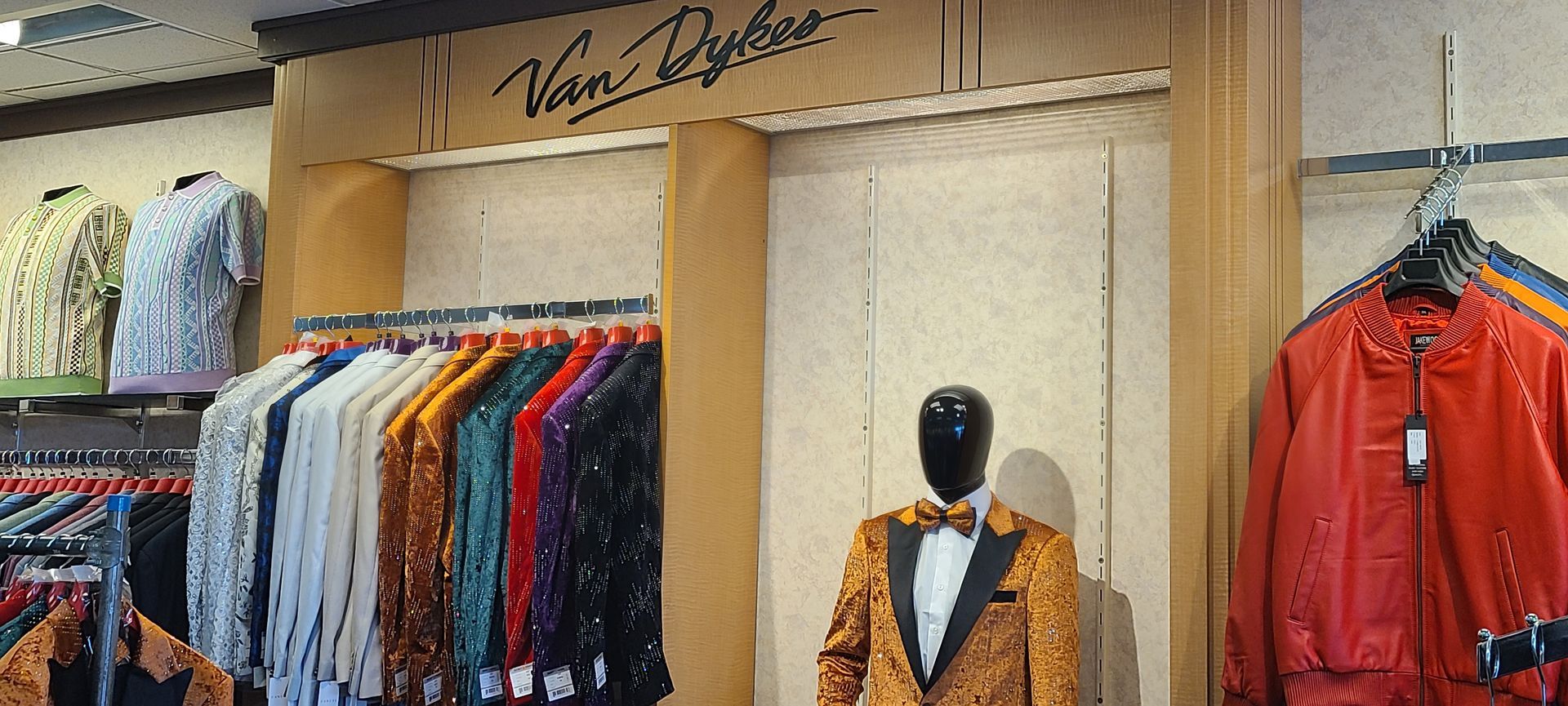Clothing store display with colorful shirts on racks and a mannequin in a patterned jacket