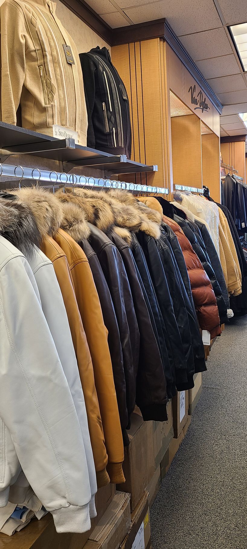 Clothing rack with winter coats in neutral and navy colors hanging in a store