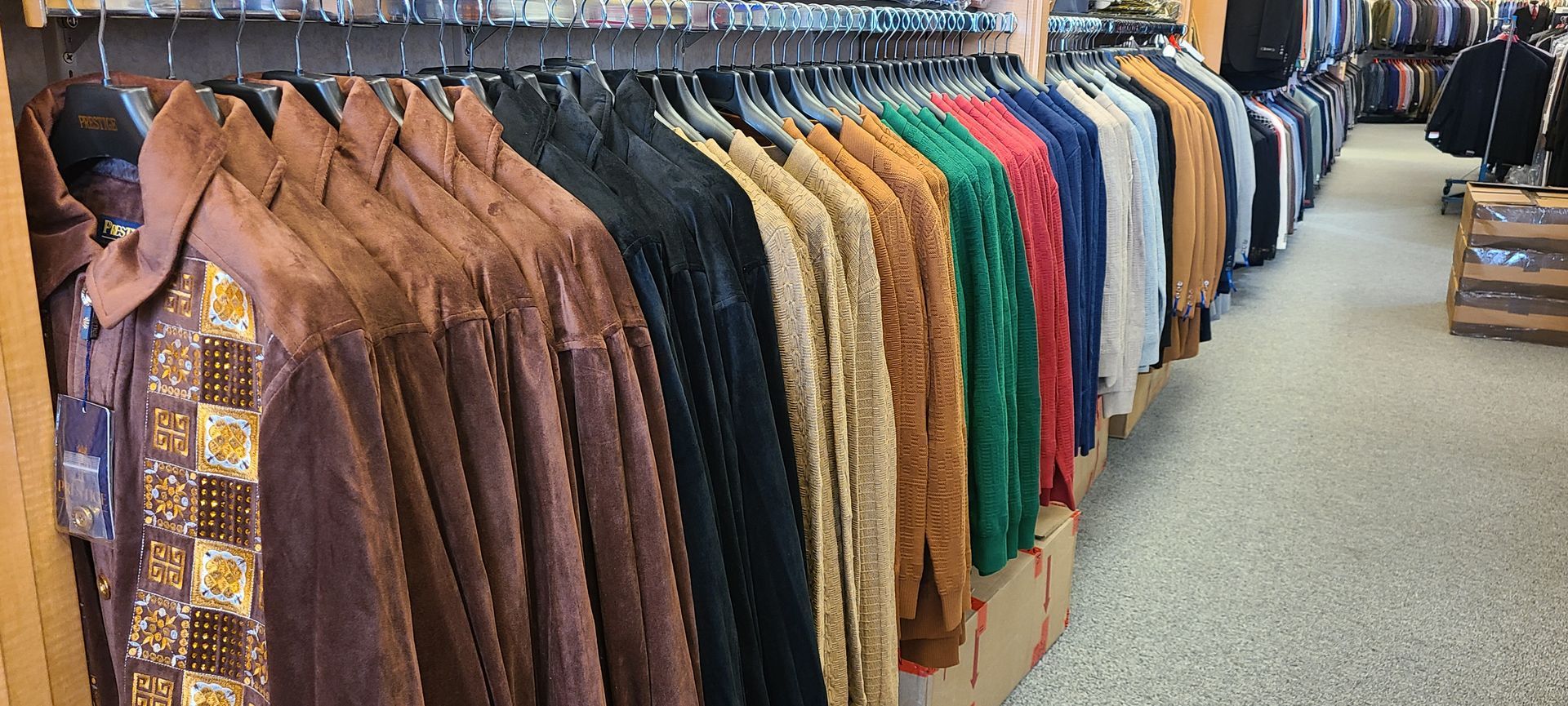 Clothing store aisle with rows of colorful jackets and coats hanging on racks