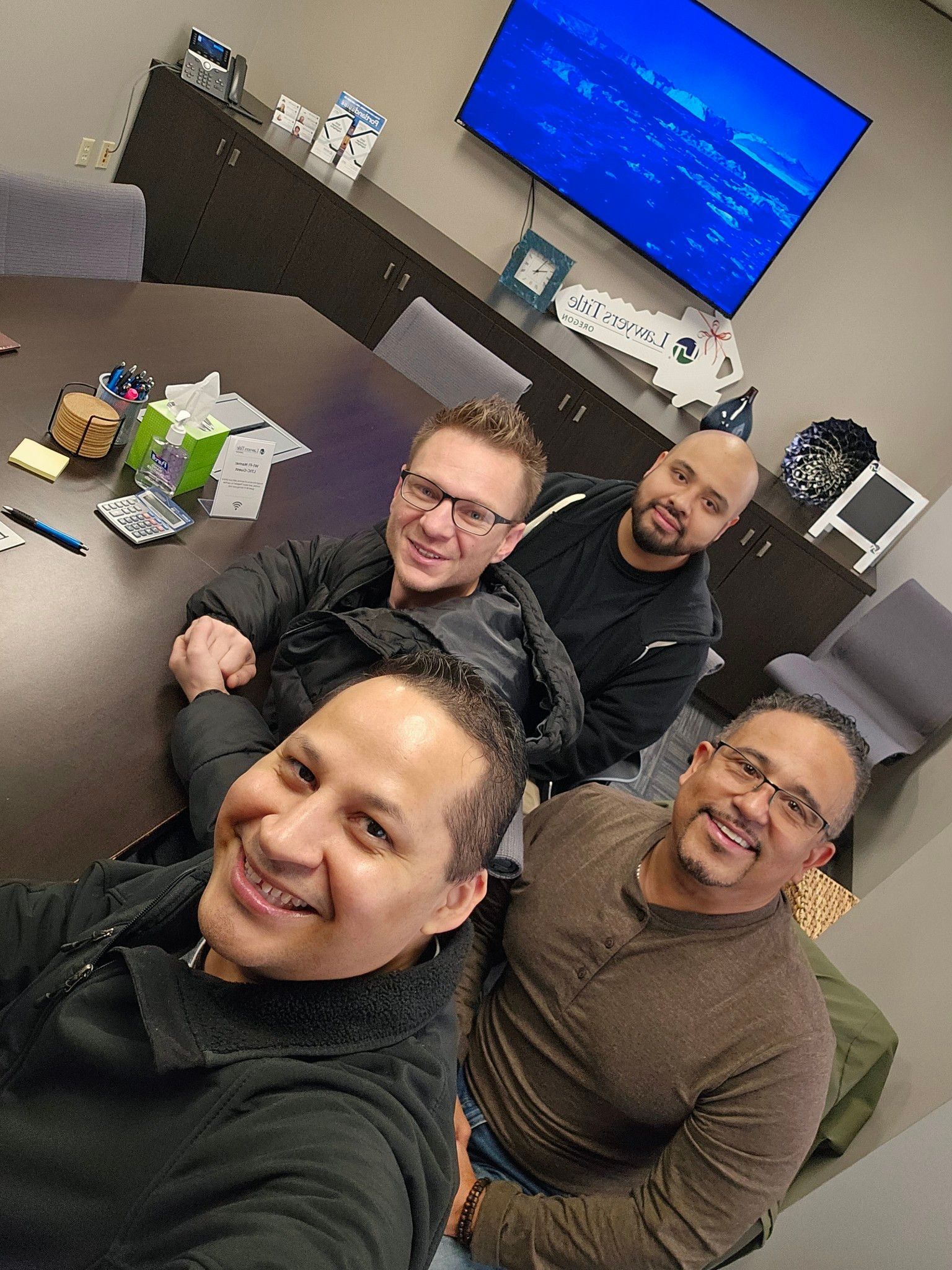 A group of men are sitting around a table in a conference room.
