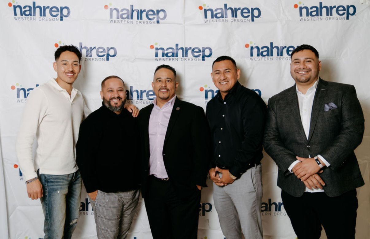 A group of men are posing for a picture in front of a nahrep backdrop.