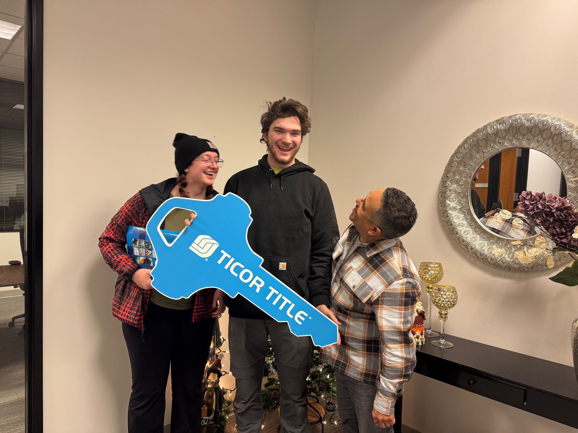 A group of people are standing next to each other holding a large blue key.