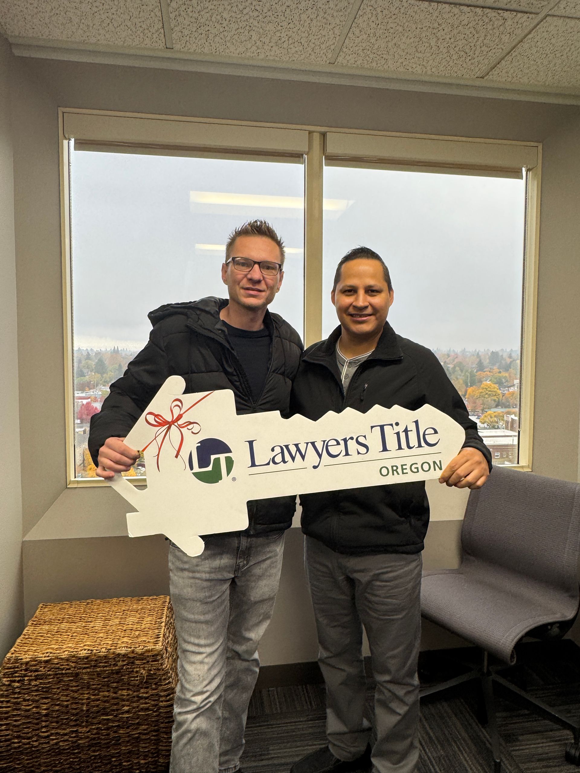 Two men are standing next to each other holding a lawyers title sign.
