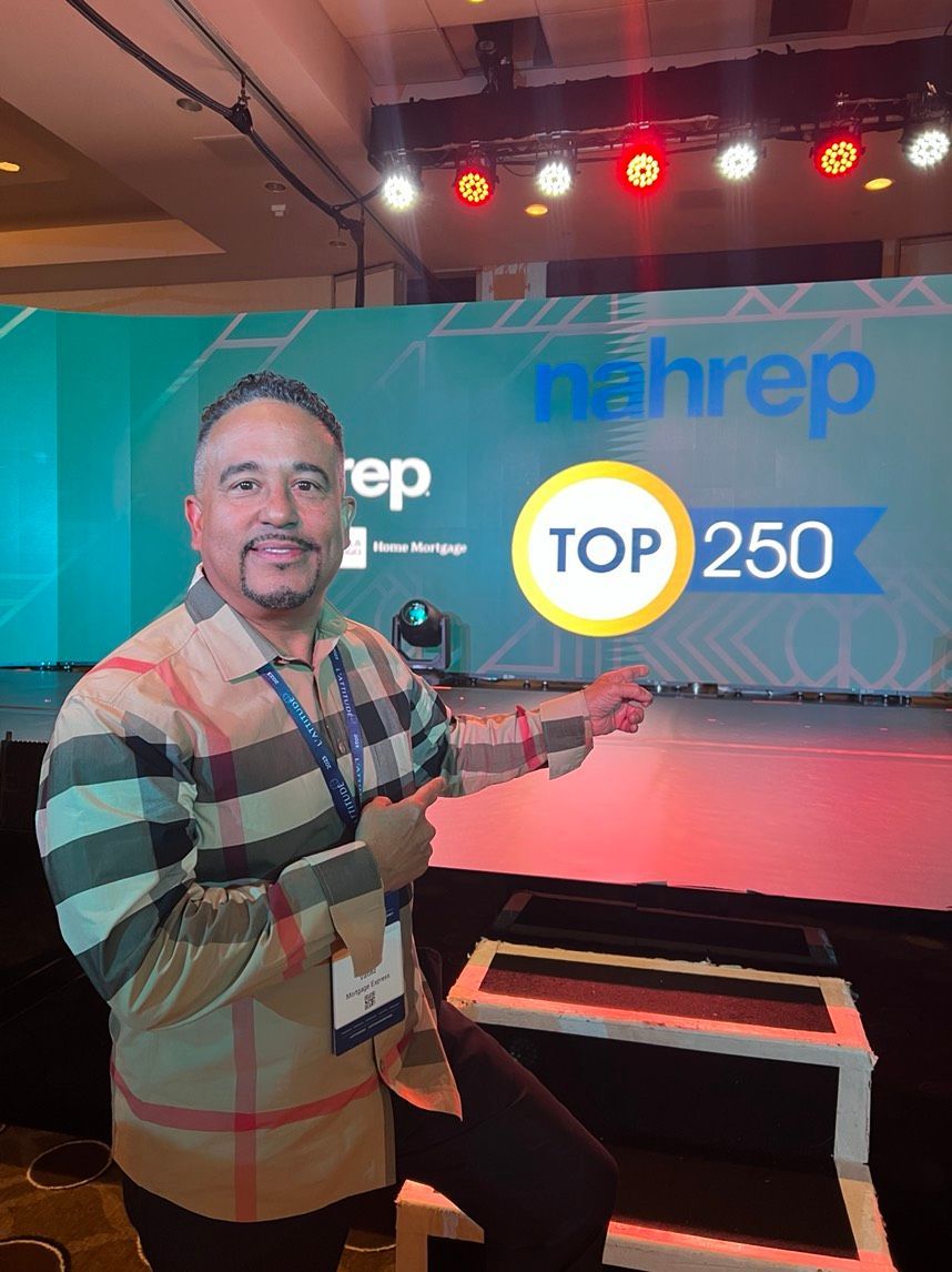 A man is standing in front of a stage with a sign that says top 250.