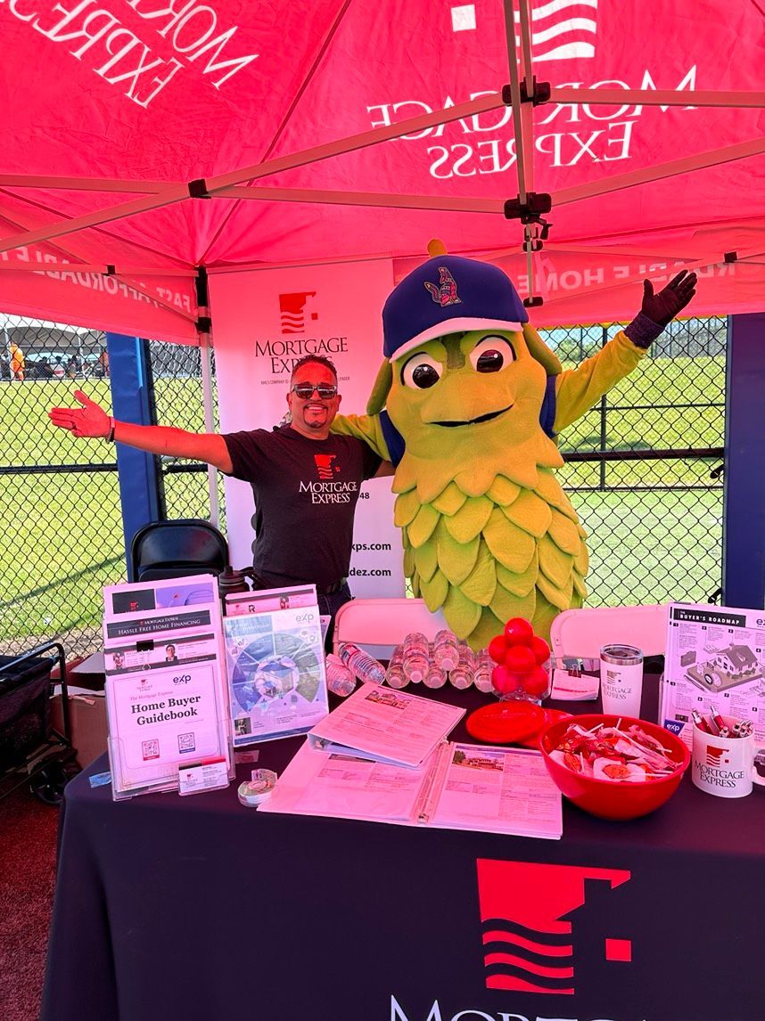 A man is standing next to a mascot at a table
