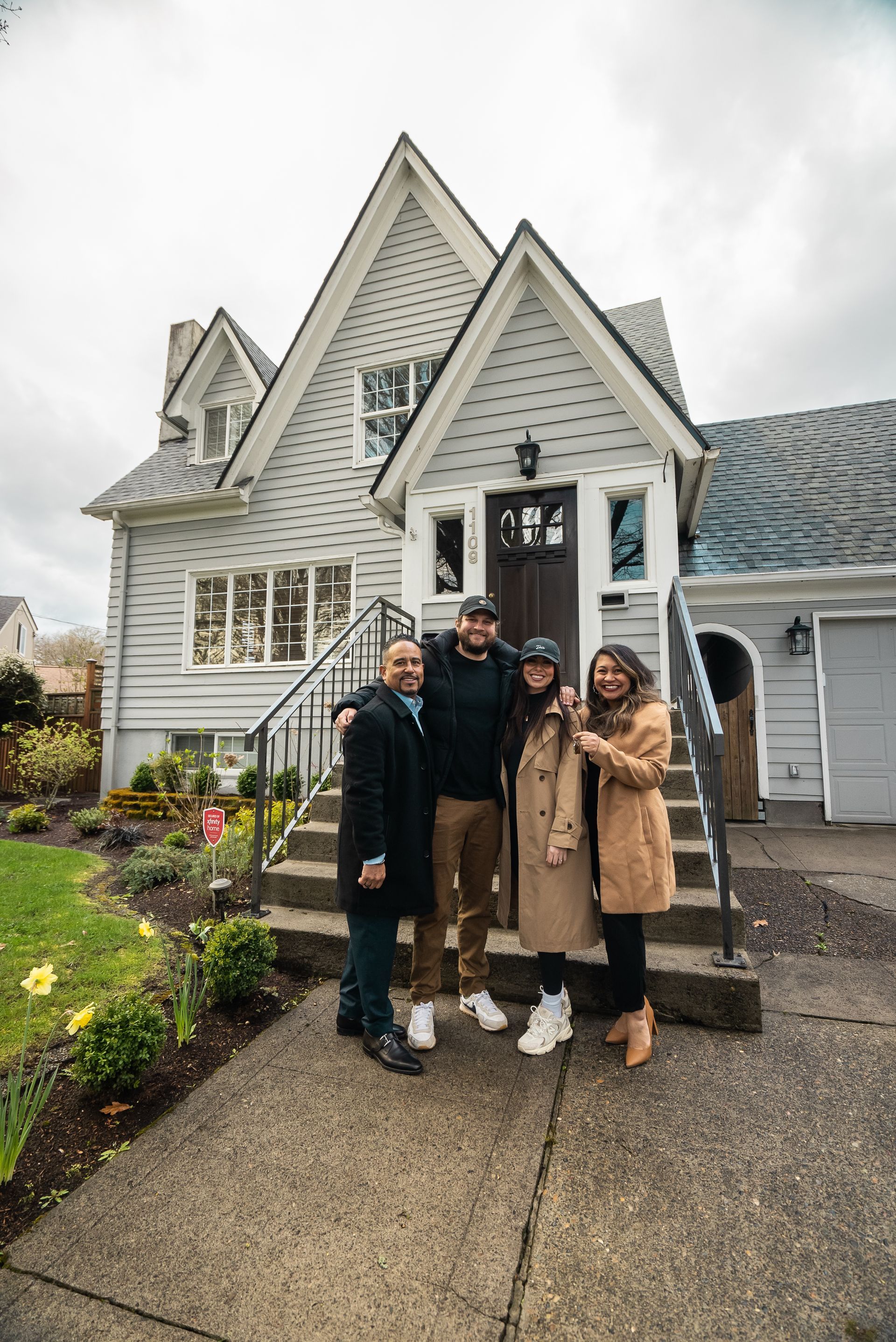 A group of people are standing in front of a house.
