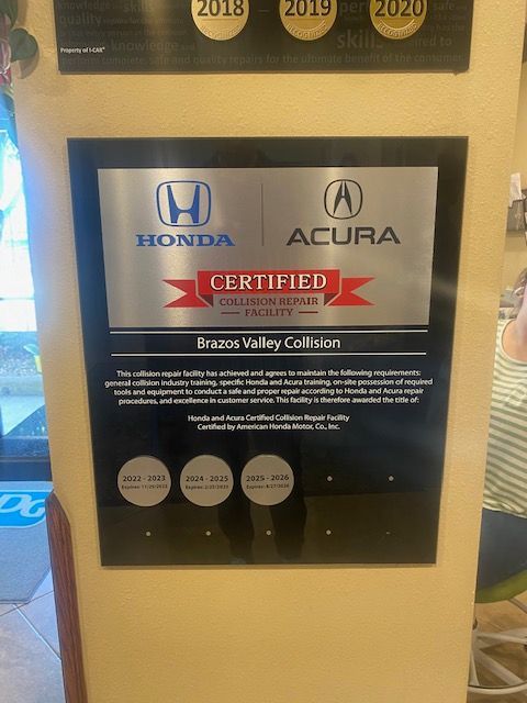 Honda Acura Certified plaque on a wall at Erick's Valley Collision, with award-year medallions above